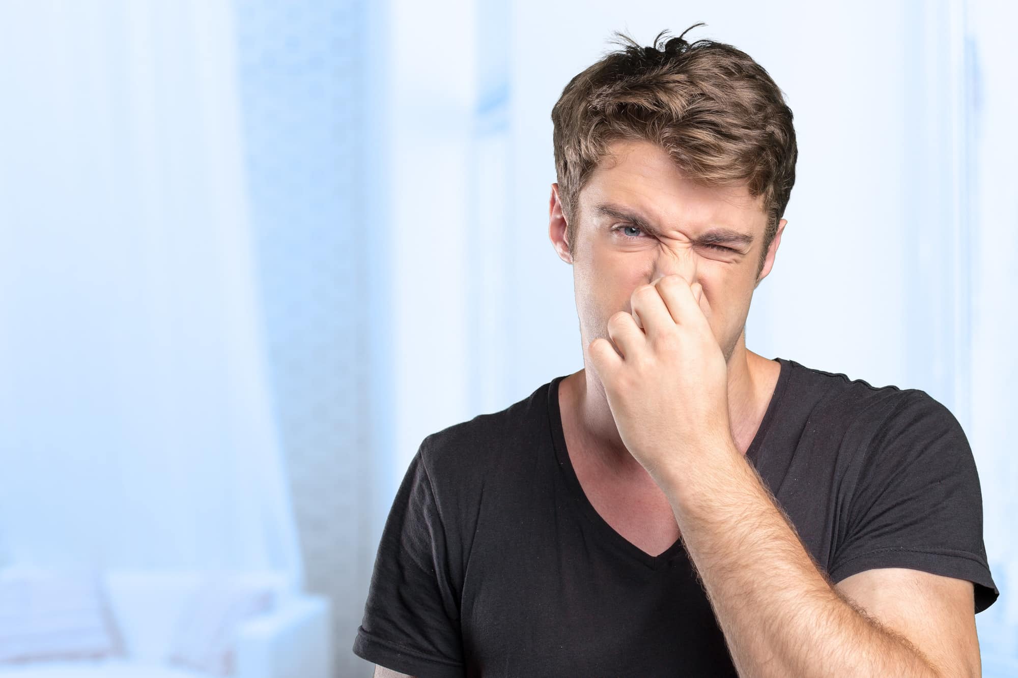 Guy plugging nose because of bad smell